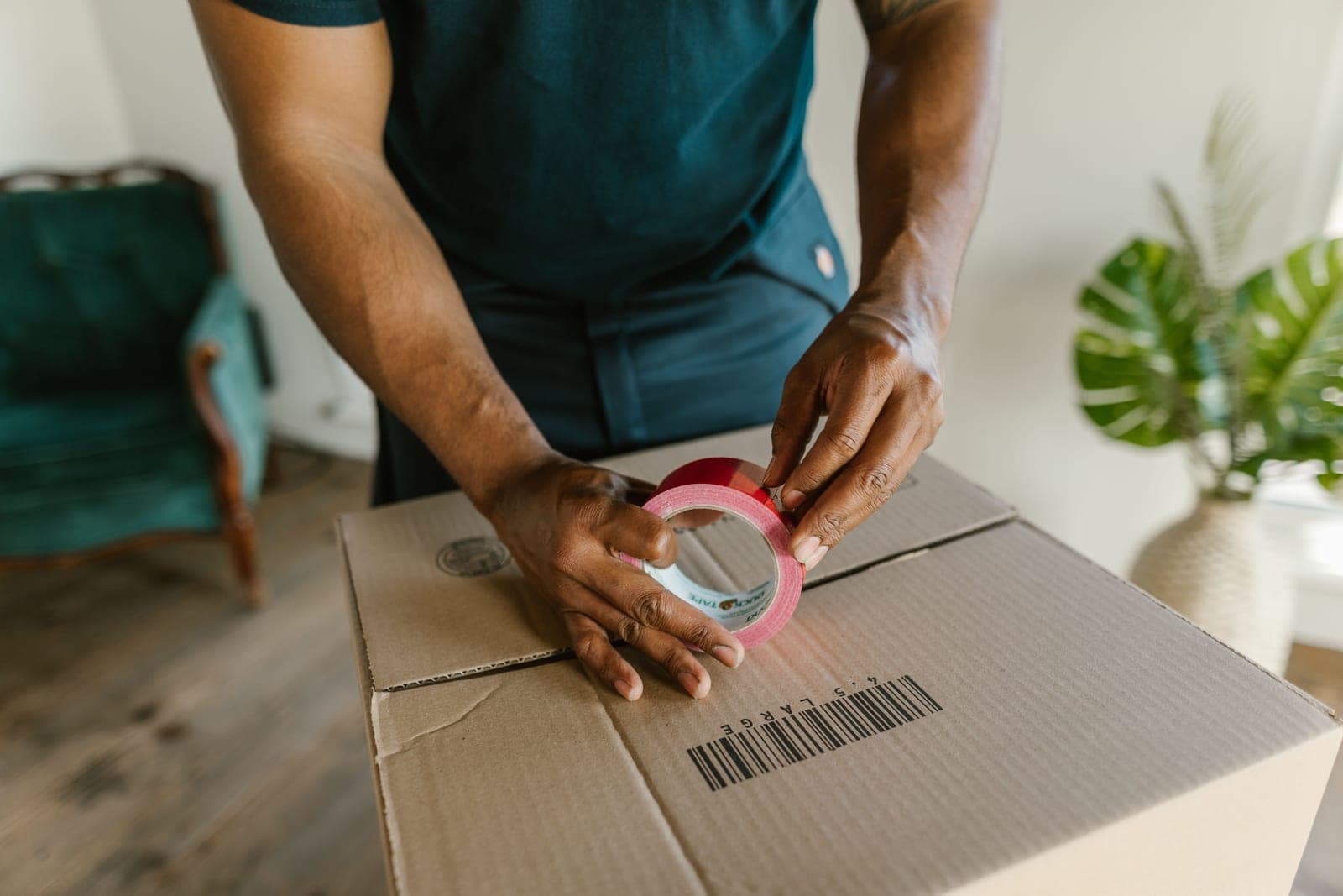 Hands packing and taping a storage box