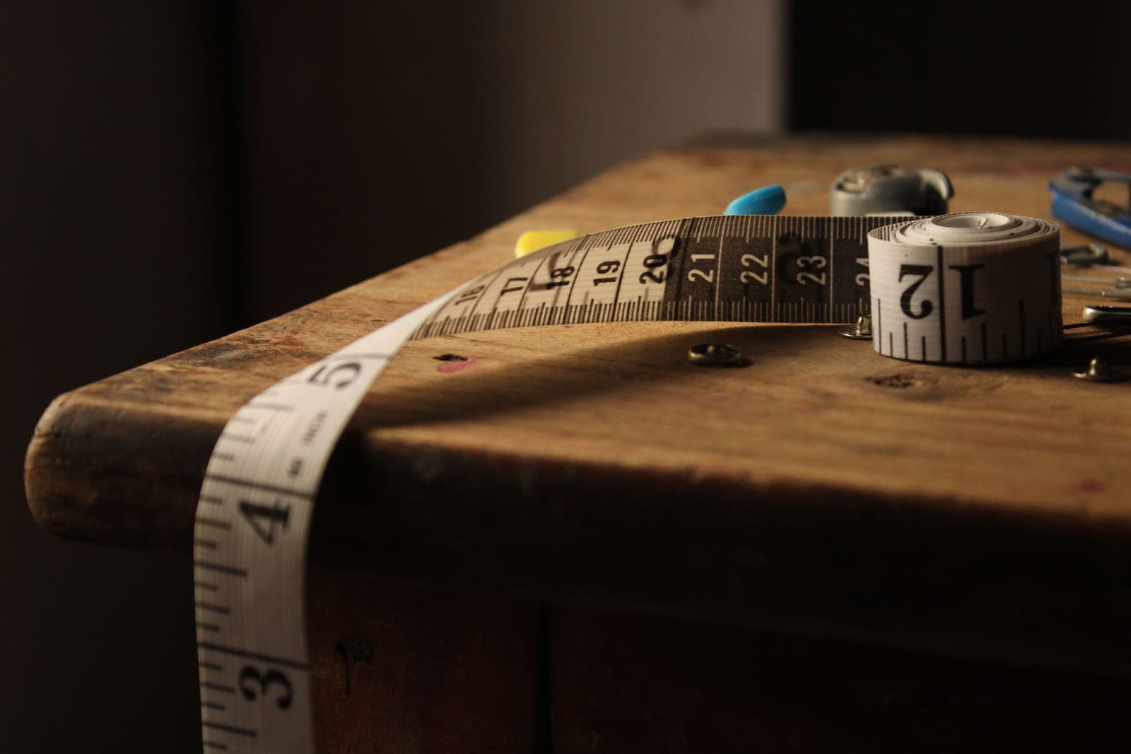 A tape measure resting on a wooden workbench