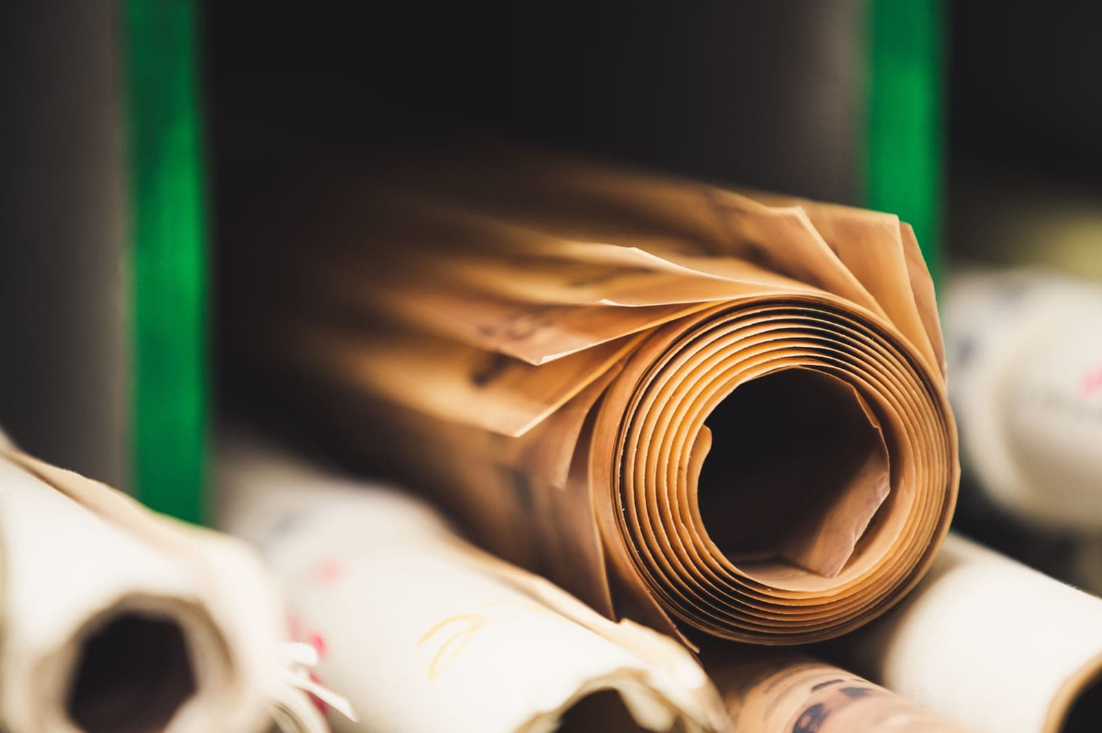 Rolls of wrapping paper stacked together on a plain surface