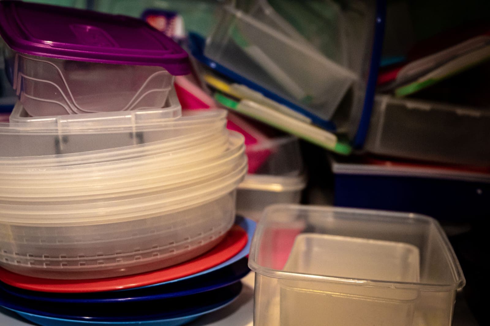 Plastic storage bins stacked on a garage shelf